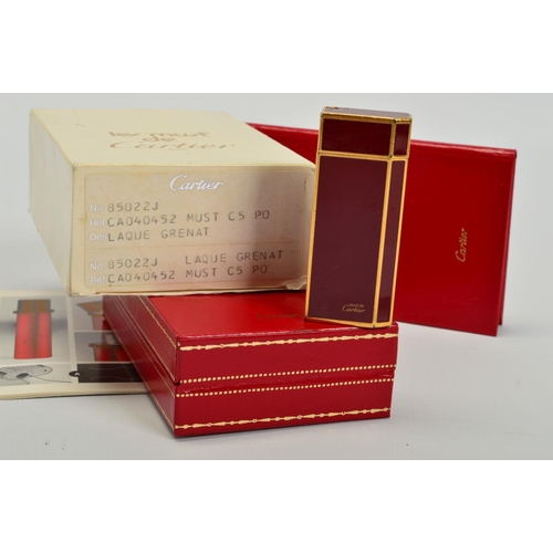 105 - MUST DE CARTIER RED ENAMEL GILT LIGHTER, base stamped Cartier Paris Plaque or G 85020J Swiss Made, l... 