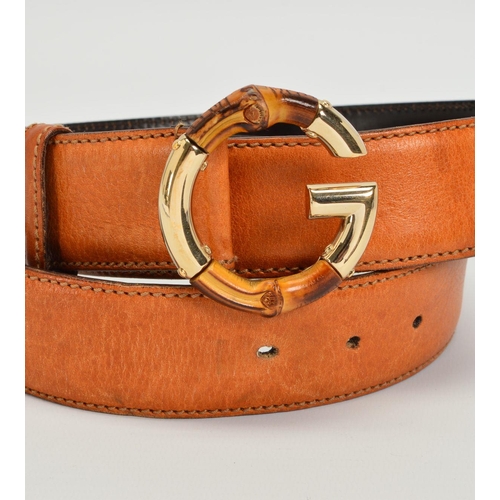 111 - A GUCCI LEATHER BELT WITH BAMBOO BUCKLE, the belt of tan leather with a G motif buckle in gold tone ... 