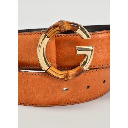 111 - A GUCCI LEATHER BELT WITH BAMBOO BUCKLE, the belt of tan leather with a G motif buckle in gold tone ... 