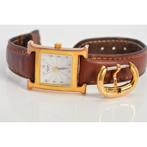 64 - A LADIES GOLD PLATED HERMES WRISTWATCH, 'H' shaped case, white radiant gold line style dial with Ara... 