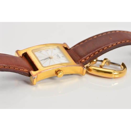 64 - A LADIES GOLD PLATED HERMES WRISTWATCH, 'H' shaped case, white radiant gold line style dial with Ara... 