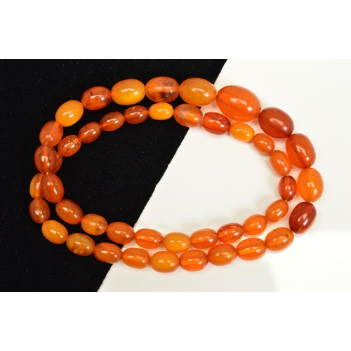 115 - A NATURAL AMBER NECKLACE, designed as graduated oval shape beads measuring 8mm to 16mm, to the screw... 