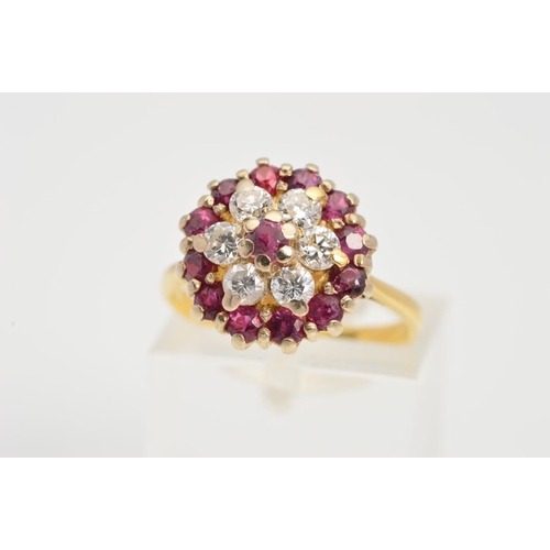83 - A RUBY AND DIAMOND CLUSTER RING, the central circular ruby within a brilliant cut diamond surround a... 