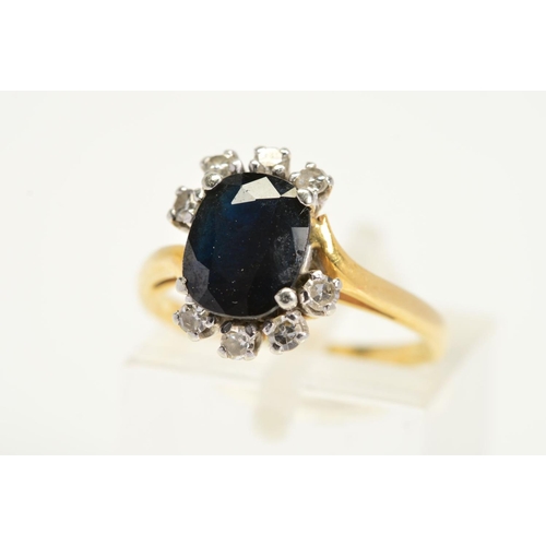 122 - AN 18CT GOLD SAPPHIRE AND DIAMOND RING, designed as a central oval shape blue sapphire with eight cl... 