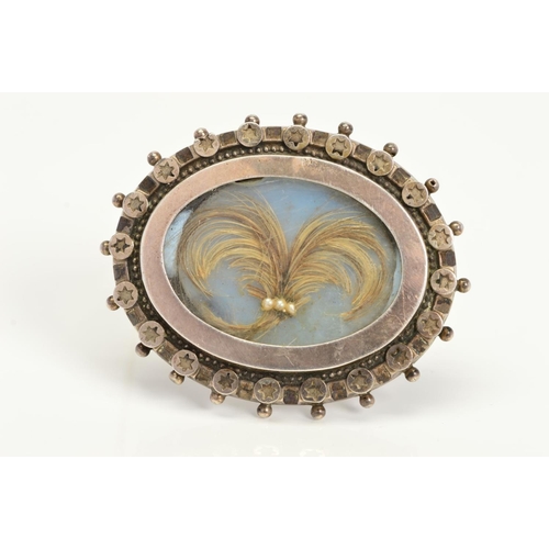 123 - A LATE VICTORIAN SILVER MEMORIAL BROOCH, of oval outline with central arranged hair panel, beaded ou... 