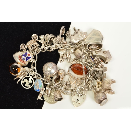 128 - A SILVER CHARM BRACELET TOGETHER WITH SEVERAL ASSORTED CHARMS, to include lockets, hinged charms, en... 