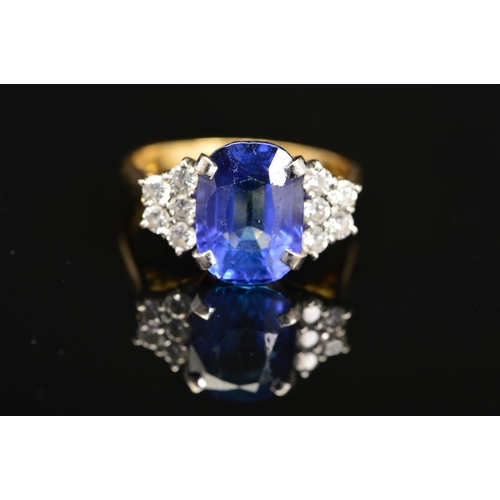 1 - A MODERN 18CT GOLD TANZANITE AND DIAMOND DRESS RING, centring on a principal cushion cut tanzanite m... 