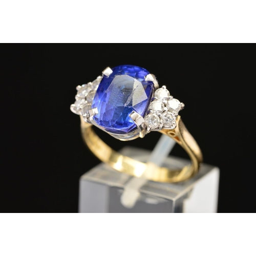 1 - A MODERN 18CT GOLD TANZANITE AND DIAMOND DRESS RING, centring on a principal cushion cut tanzanite m... 