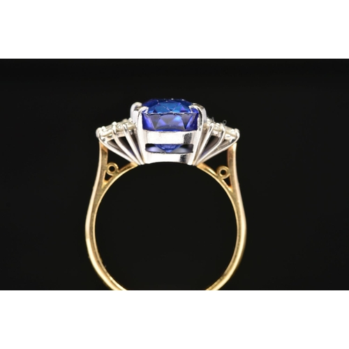 1 - A MODERN 18CT GOLD TANZANITE AND DIAMOND DRESS RING, centring on a principal cushion cut tanzanite m... 