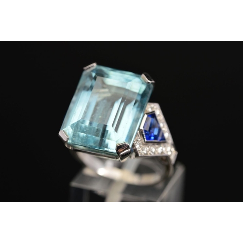 10 - A MODERN AQUAMARINE, SAPPHIRE AND DIAMOND DRESS RING, centring on a principal trap cut aquamarine me... 