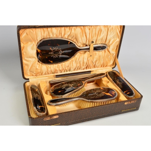 104 - A CASED GEORGE V SILVER AND TORTOISESHELL PIQUE WORK DRESSING TABLE SET, comprising hand mirror, fou... 