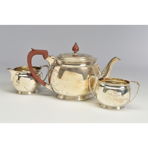 121 - A GEORGE VI SILVER THREE PIECE TEA SERVICE, of oval form, brown bakelite handle and finial to the te... 