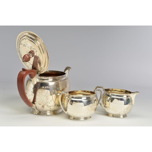 121 - A GEORGE VI SILVER THREE PIECE TEA SERVICE, of oval form, brown bakelite handle and finial to the te... 