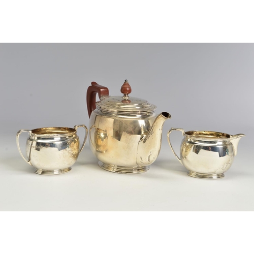 121 - A GEORGE VI SILVER THREE PIECE TEA SERVICE, of oval form, brown bakelite handle and finial to the te... 