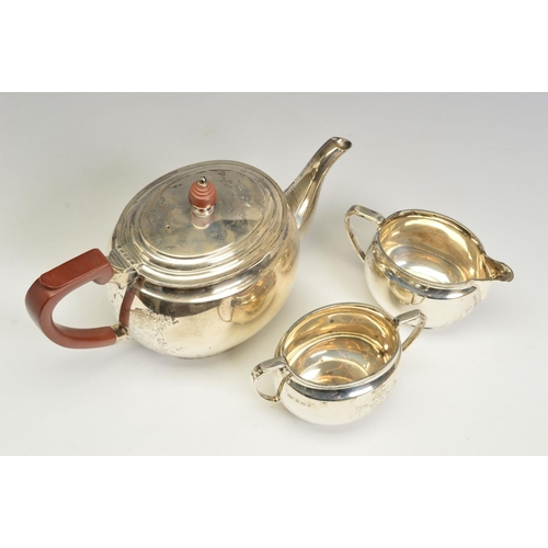 121 - A GEORGE VI SILVER THREE PIECE TEA SERVICE, of oval form, brown bakelite handle and finial to the te... 