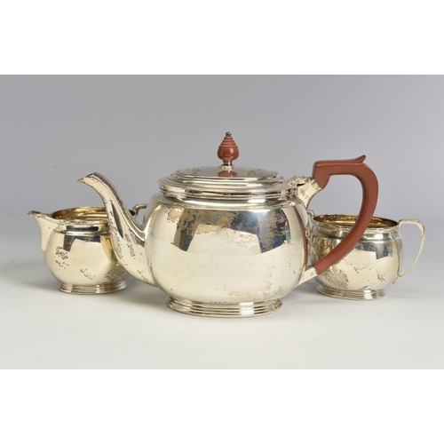 121 - A GEORGE VI SILVER THREE PIECE TEA SERVICE, of oval form, brown bakelite handle and finial to the te... 