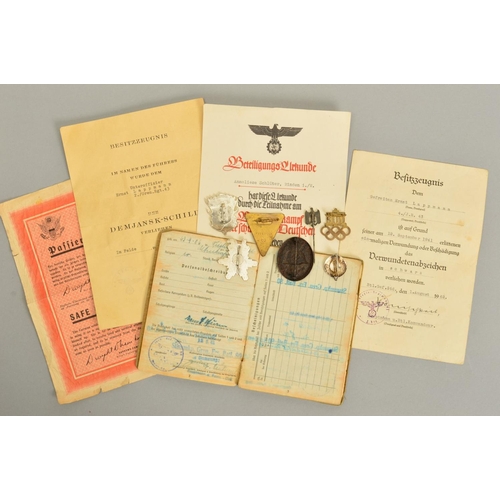 142 - A NUMBER OF GERMAN WWII 3RD REICH MILITARY BADGES AND PAPERWORK, comprising of soldiers 'Soldbuch' 2... 