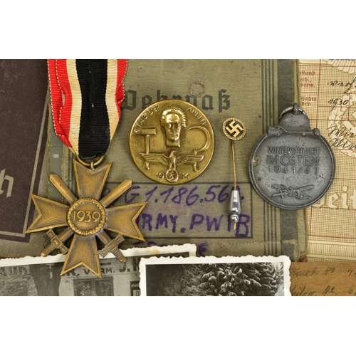 153 - A GROUP OF 3RD REICH WWII MEDALS AND BADGES, plus paperwork relating to two members of the same fami... 