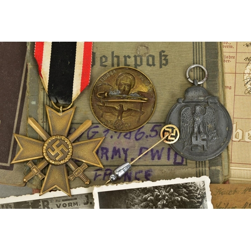 153 - A GROUP OF 3RD REICH WWII MEDALS AND BADGES, plus paperwork relating to two members of the same fami... 