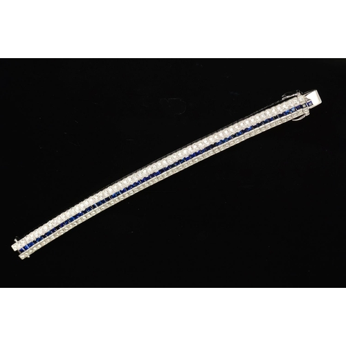 16 - A MODERN SAPPHIRE AND DIAMOND LINE BRACELET, centring on a line of calibre square cut blue sapphires... 