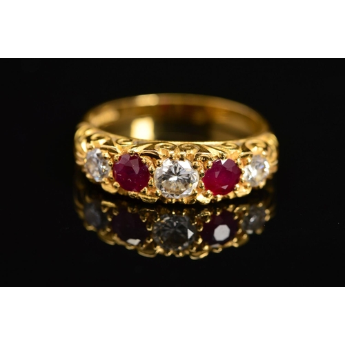 25 - A LATE 20TH CENTURY 18CT RUBY AND DIAMOND CARVED HALF HOOP FIVE STONE RING, scroll carved shoulders ... 