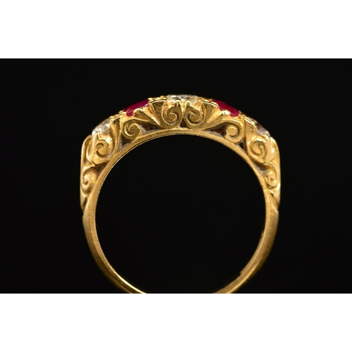 25 - A LATE 20TH CENTURY 18CT RUBY AND DIAMOND CARVED HALF HOOP FIVE STONE RING, scroll carved shoulders ... 