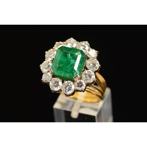 28 - A LATE 20TH CENTURY LARGE EMERALD AND DIAMOND CLUSTER RING, emerald cut emerald measuring approximat... 