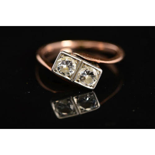 36 - A MID 20TH CENTURY TWO STONE DIAMOND RING, each diamond grain set within a box setting, cross over d... 