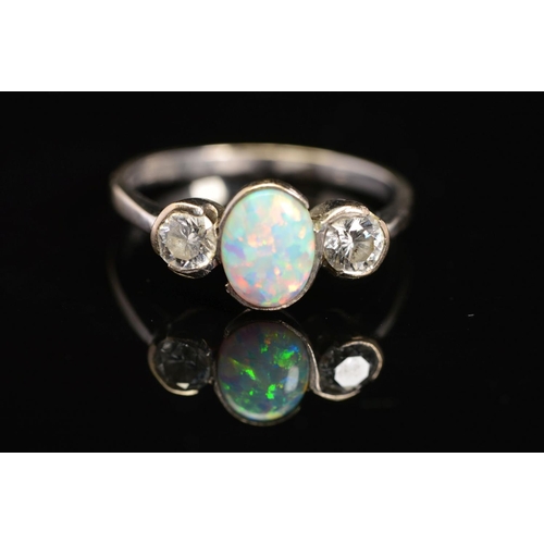 37 - AN 18CT WHITE GOLD, OPAL AND DIAMOND RING, designed as a central oval opal cabochon flanked to eithe... 