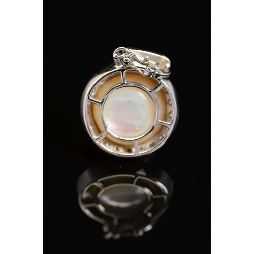 41 - A MODERN 18CT WHITE GOLD MABE PEARL AND DIAMOND PENDANT, a round Mabe pearl enclosed within a border... 