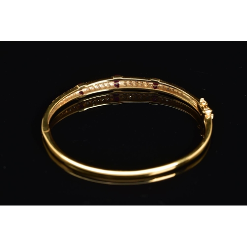 45 - A MODERN 18CT GOLD, RUBY AND DIAMOND HALF HOOP BANGLE, an oval hinged bangle fitted to tongue and bo... 