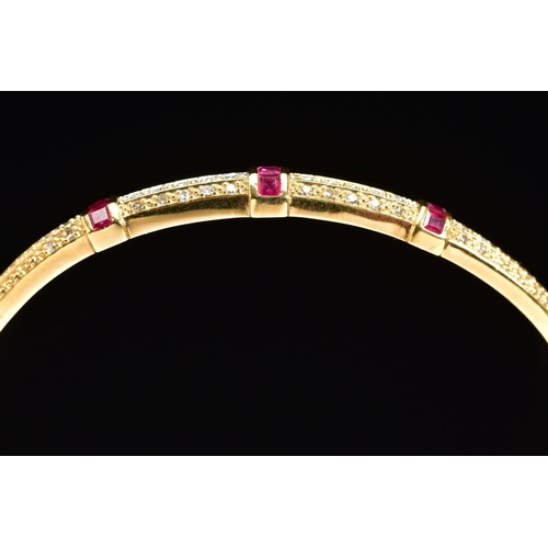 45 - A MODERN 18CT GOLD, RUBY AND DIAMOND HALF HOOP BANGLE, an oval hinged bangle fitted to tongue and bo... 