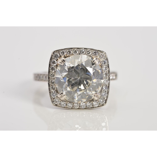 50 - A STUNNING MODERN LARGE DIAMOND RING, centring on a transitional round brilliant cut diamond, enclos... 