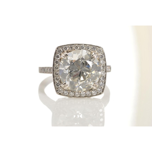 50 - A STUNNING MODERN LARGE DIAMOND RING, centring on a transitional round brilliant cut diamond, enclos... 