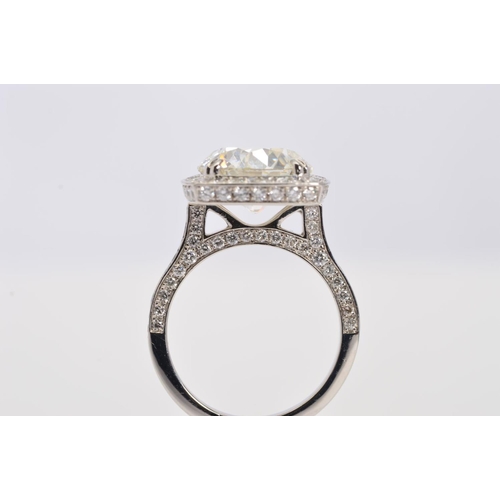 50 - A STUNNING MODERN LARGE DIAMOND RING, centring on a transitional round brilliant cut diamond, enclos... 