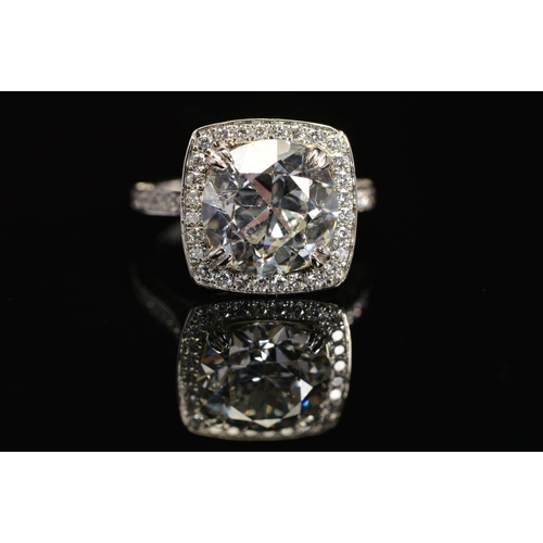 50 - A STUNNING MODERN LARGE DIAMOND RING, centring on a transitional round brilliant cut diamond, enclos... 