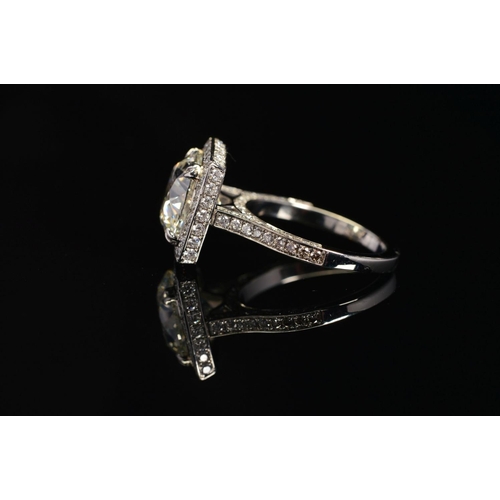 50 - A STUNNING MODERN LARGE DIAMOND RING, centring on a transitional round brilliant cut diamond, enclos... 