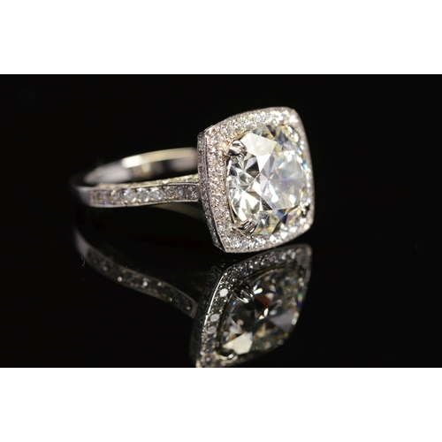 50 - A STUNNING MODERN LARGE DIAMOND RING, centring on a transitional round brilliant cut diamond, enclos... 