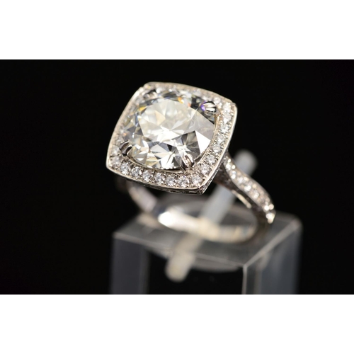 50 - A STUNNING MODERN LARGE DIAMOND RING, centring on a transitional round brilliant cut diamond, enclos... 