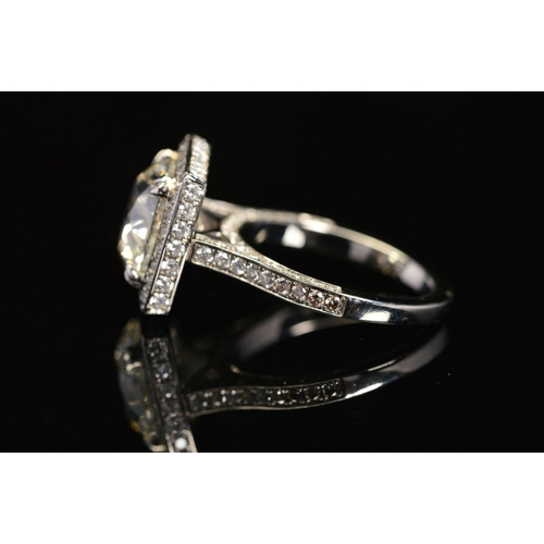 50 - A STUNNING MODERN LARGE DIAMOND RING, centring on a transitional round brilliant cut diamond, enclos... 