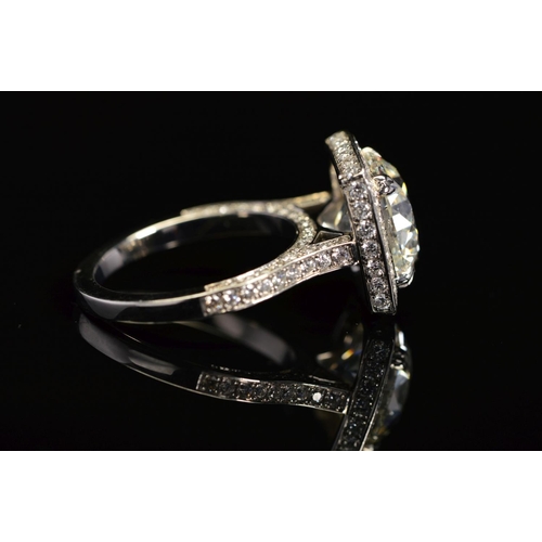 50 - A STUNNING MODERN LARGE DIAMOND RING, centring on a transitional round brilliant cut diamond, enclos... 