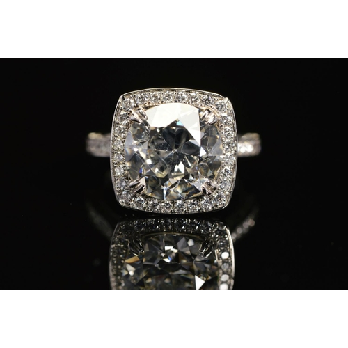 50 - A STUNNING MODERN LARGE DIAMOND RING, centring on a transitional round brilliant cut diamond, enclos... 