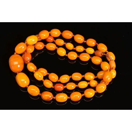 7 - A NATURAL AMBER NECKLACE, designed as fifty-five graduated beads measuring approximately 13mm to 27m... 