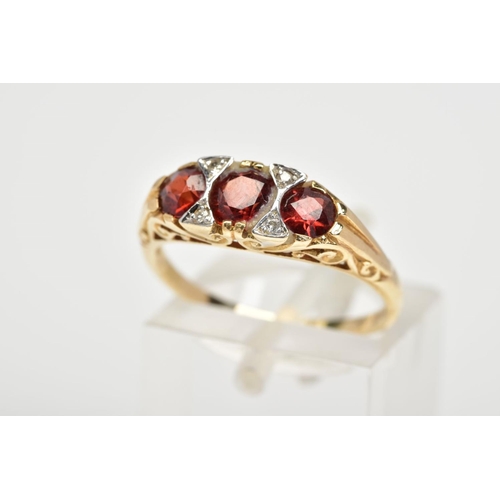 110 - A 9CT GOLD GARNET AND DIAMOND RING, with three graduated circular cut garnets interspaced with round... 
