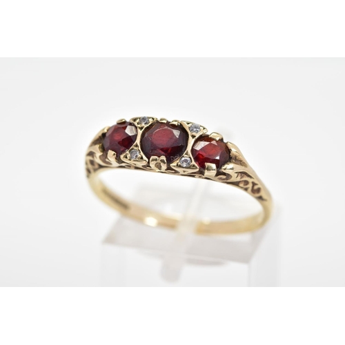 143 - A 9CT GOLD GARNET BOAT RING, designed with three graduated circular garnets interspaced with brillia... 