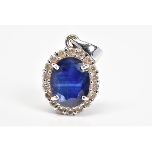 17 - AN 18CT WHITE GOLD SAPPHIRE AND DIAMOND CLUSTER PENDANT, designed as a central oval sapphire within ... 