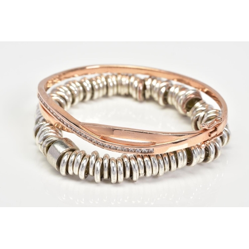 20 - TWO BRACELETS, the first an elasticated bracelet, the second a silver hinged bangle of crossover des... 