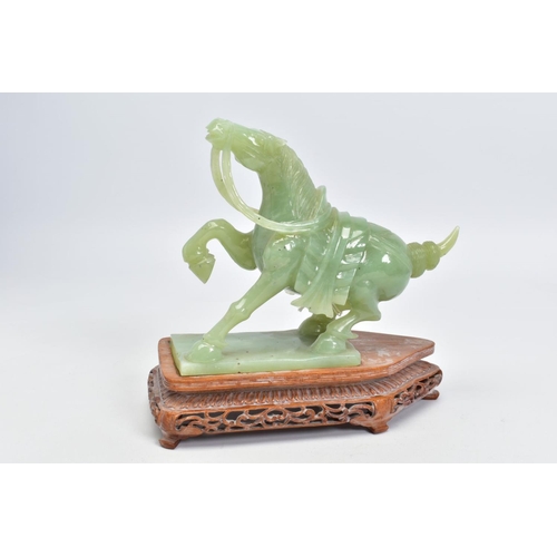 240 - A CARVED GREEN BOWENITE HORSE ORNAMENT, together with a carved wooden plinth, horse measuring approx... 