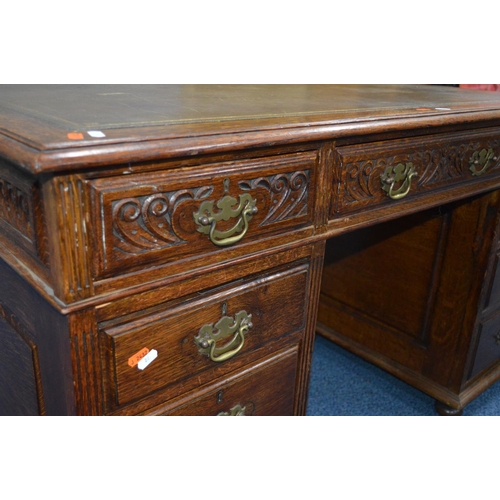 1685 - AN EARLY 20TH CENTURY CARVED OAK PEDESTAL DESK, dark green gilt tooled leather inlay top and nine as... 