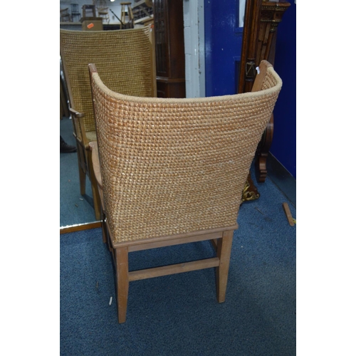 1694 - AN EARLY 20TH CENTURY LIGHT OAK ORKNEY CHAIR, the curved woven straw back flanked by open arm rests,... 